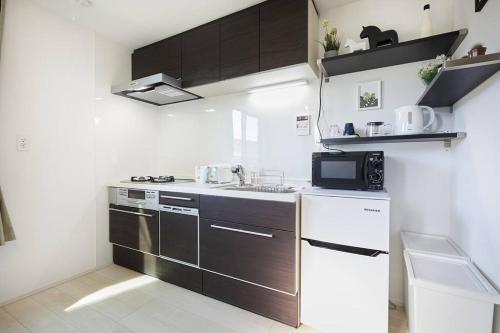 a small kitchen with a sink and a microwave at Shinkoiwa house at JR line.Easy to airport&Disney. in Tokyo
