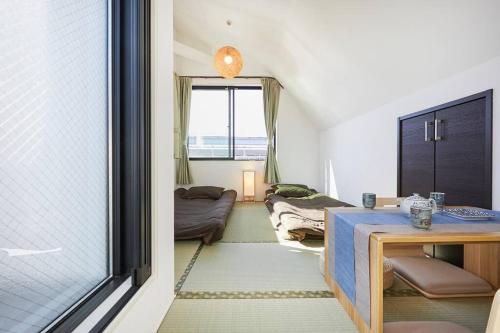Pokój z 2 łóżkami, stołem i oknem w obiekcie Shinkoiwa house at JR line.Easy to airport&Disney. w Tokio
