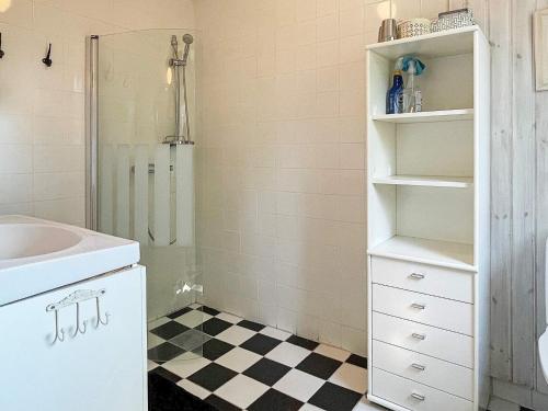 a white bathroom with a sink and a shower at Holiday home ELLÖS IX in Ellös