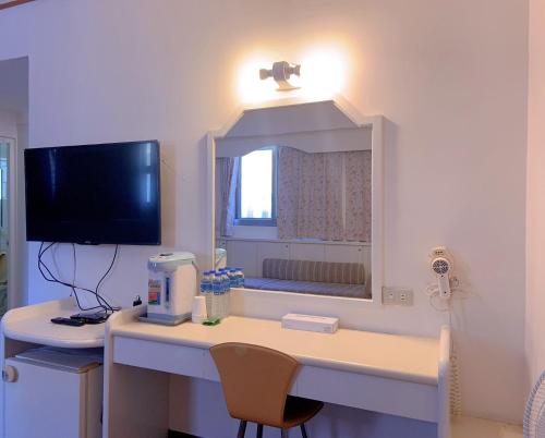 a room with a desk with a computer and a mirror at Traveler Hotel Taitung in Taitung City
