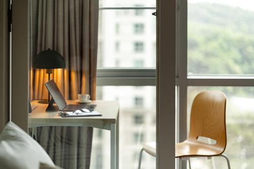 a desk with a laptop and a chair next to a window at Urbanstay Residence Dongtan in Hwaseong