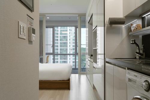 a kitchen with a bed and a large window at Urbanstay Residence Dongtan in Hwaseong