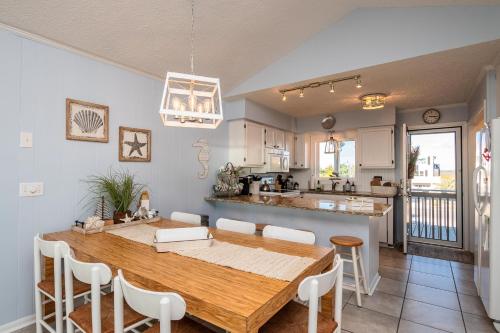 uma cozinha e sala de jantar com uma mesa de madeira e cadeiras em Caswell Cabana by Oak Island Accommodations em Caswell Beach