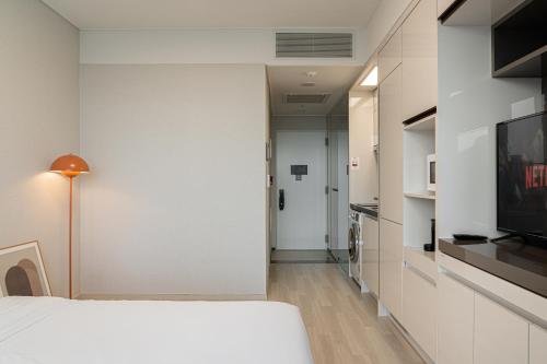 a bedroom with a white bed and a tv at Urbanstay Residence Dongtan in Hwaseong