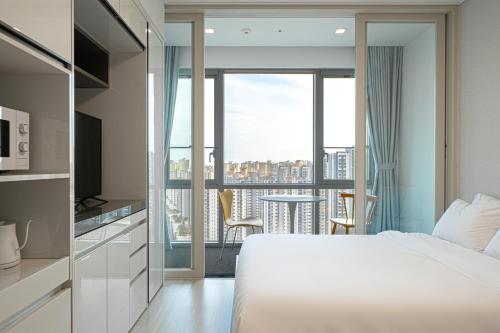 a bedroom with a bed and a view of a city at Urbanstay Residence Dongtan in Hwaseong
