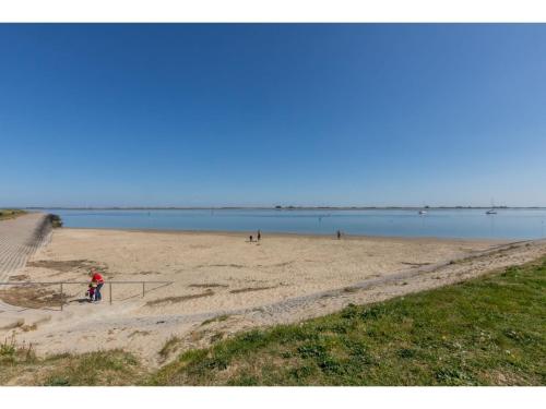 a person riding a bike on a sandy beach at Apartment in Sint-Annaland with Water Views in Sint Annaland