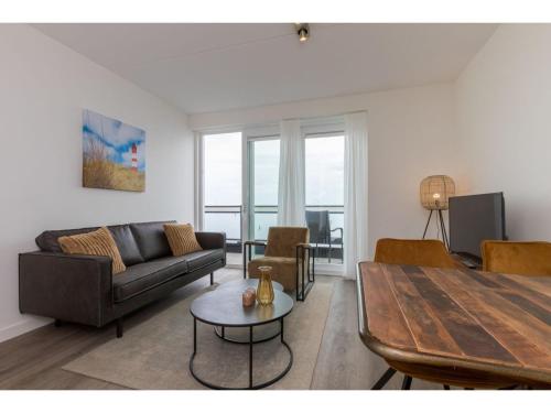 a living room with a couch and a table at Apartment in Sint-Annaland with Water Views in Sint Annaland