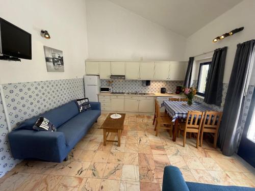 a living room with a blue couch and a table at Attached quaint Farmhouse in Montemor o Novo with Swimming Pool in Montemor-o-Novo