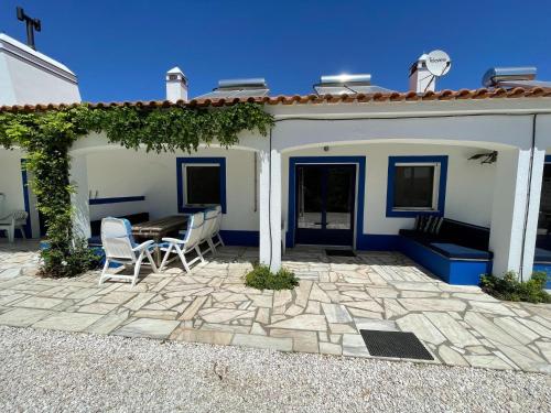 a patio with a table and chairs in front of a house at Attached quaint Farmhouse in Montemor o Novo with Swimming Pool in Montemor-o-Novo