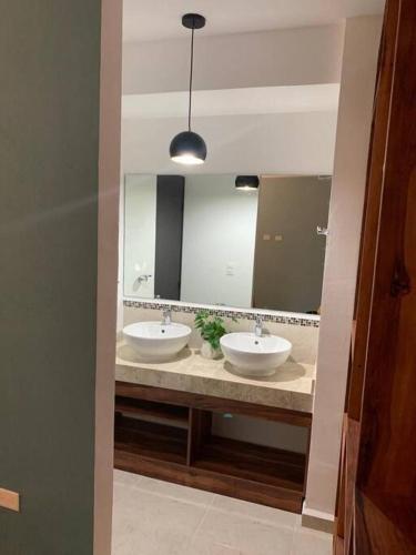 a bathroom with two sinks and a large mirror at Apartamento exclusivo piscina, jaccuzi, céntrico. in Cancún