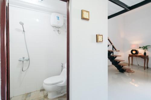 a bathroom with a toilet and a shower stall at D'Tamblingan Guest House at Taman Griya Jimbaran RedPartner - Minimum Stay 30 Nights in Jimbaran