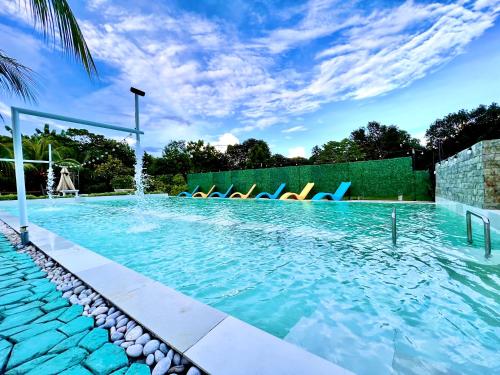 - une piscine avec des chaises bleues dans l'eau dans l'établissement HOTEL Pinc, à General Santos