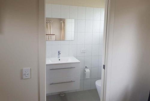 a white bathroom with a sink and a toilet at Mullumbimby Studio in Mullumbimby