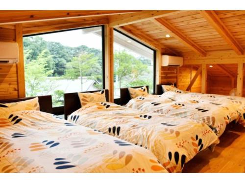 three beds in a room with a large window at Polar Haus NishiKaruisawa1 - Vacation STAY 87981v in Oiwake