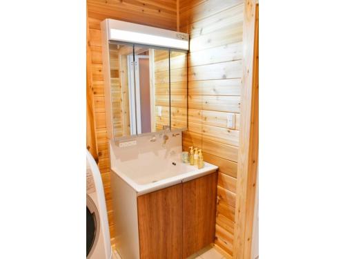 uma casa de banho com um lavatório e um espelho em Polar Haus NishiKaruisawa1 - Vacation STAY 87981v em Oiwake