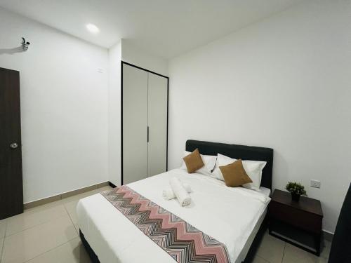 a bedroom with a large white bed with brown pillows at Desaru Johor by Glex in Desaru