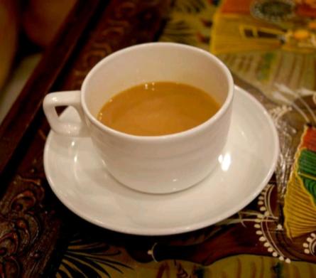 una taza de café en un plato en una mesa en Rama HS, en Agra