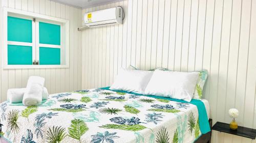 a bedroom with a bed with a blue and white comforter at Posada Camp Inn Providencia in Providencia