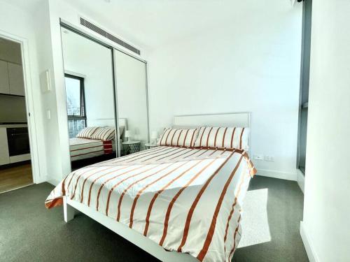 a bedroom with a bed and a large window at 1 Bedroom Modern Apartment Near Crown and CBD in Melbourne