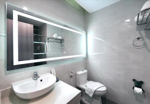 a bathroom with a sink and a toilet and a mirror at S Resort El Nido in El Nido