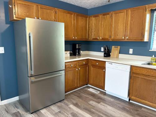 eine Küche mit einem Kühlschrank aus Edelstahl und Holzschränken in der Unterkunft Cozy house near Douglas Lake Family and Pet friendly Quiet location in Sevierville