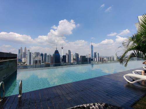 a swimming pool on the roof of a building with a city skyline at StarsBed KLCC Skyview Roof Pool Hostel in Kuala Lumpur