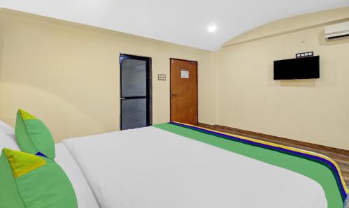 a bedroom with a bed and a tv on the wall at Treebo Majestic Palms, 2 Km From Colva Beach in Benaulim