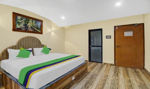 a bedroom with a large bed and a door at Treebo Majestic Palms, 2 Km From Colva Beach in Benaulim