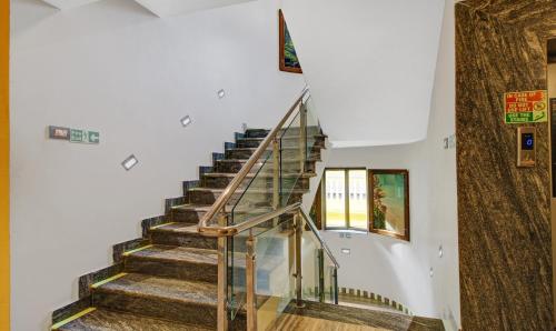 a staircase in a house with a glass railing at Treebo Majestic Palms, 2 Km From Colva Beach in Benaulim
