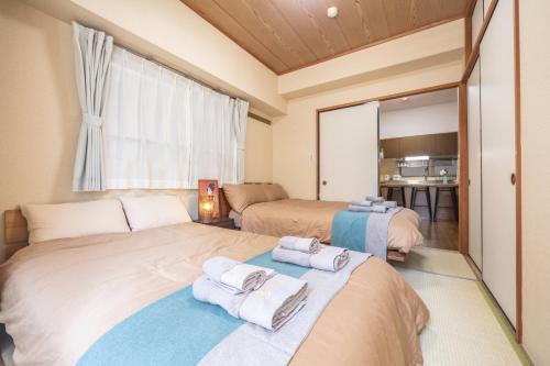 sypialnia z 2 łóżkami i ręcznikami w obiekcie nestay apartment tokyo akihabara 2A w Tokio