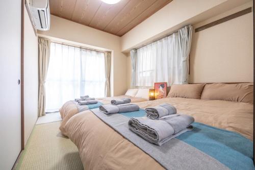 a bedroom with two beds and a large window at nestay apartment tokyo akihabara 2A in Tokyo