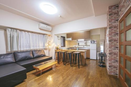 a living room with a couch and a kitchen at nestay apartment tokyo akihabara 2A in Tokyo