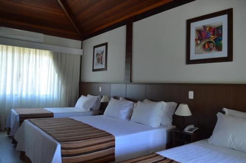 a hotel room with two beds with white sheets at Pousada Terê Parque in Teresópolis