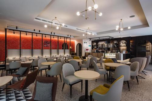 a restaurant with tables and chairs and a bar at OLAH Poshtel - Taichung Station in Taichung