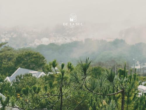 a view of a mountain with palm trees in the foreground at De La Sol Villa Dalat in Da Lat