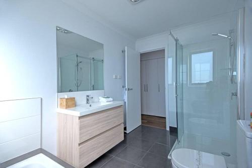 a bathroom with a sink and a shower and a toilet at Sandbar Beach House in Coles Bay