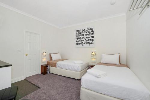 Habitación pequeña con 2 camas y paredes blancas. en Lavender House York, en York