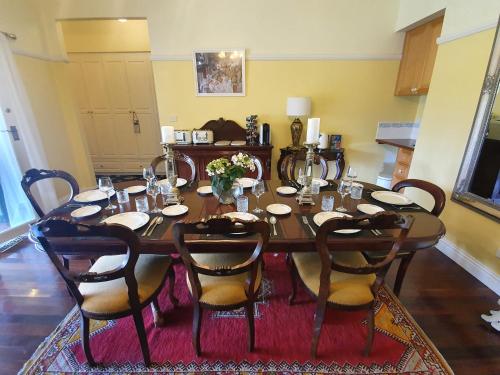 a dining room with a table with chairs and a table at Rosebank Guesthouse in Healesville
