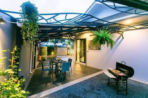 un patio di una casa con tavolo e sedie di Nut & Non Pool Villa by Duangtham a Ban Khlong Haeng