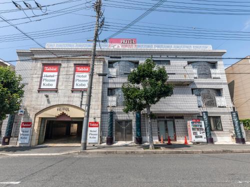 ein Gebäude an der Ecke einer Straße in der Unterkunft Tabist Hotel Please Kobe in Kōbe