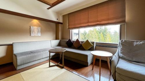 a living room with a couch and a window at Lake Shikotsu Tsuruga Resort Spa Mizu no Uta in Chitose