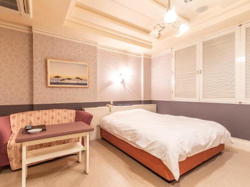 a bedroom with a bed and a table at Tabist Hotel Please Kobe in Kobe