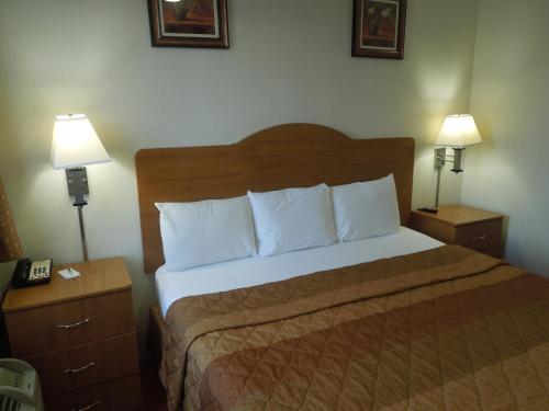 a bedroom with a bed with two nightstands and two lamps at The Vue Express @ 39th Street in Brooklyn