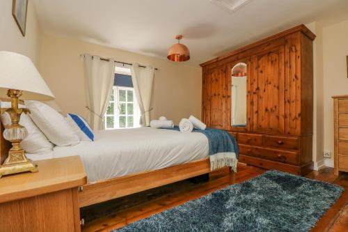 a bedroom with a bed and a desk and a window at 9 Copes Gardens in Truro