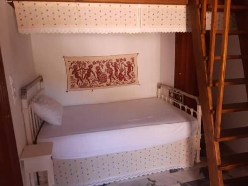 Ce lit superposé se trouve dans un dortoir avec une échelle. dans l'établissement Bella Vista Montagna, à Apérathos