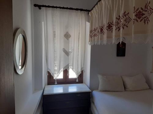 a bedroom with a bed and a window with curtains at Bella Vista Montagna in Apeiranthos