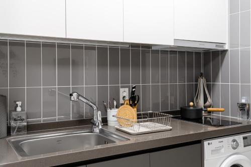 a kitchen counter with a sink and a dishwasher at Urbanstay Busan Cityhall in Busan