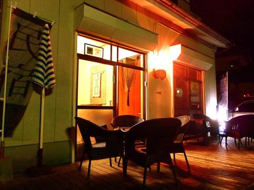 a restaurant with a table and chairs in a room at Aoshima Guesthouse Hooju in Miyazaki