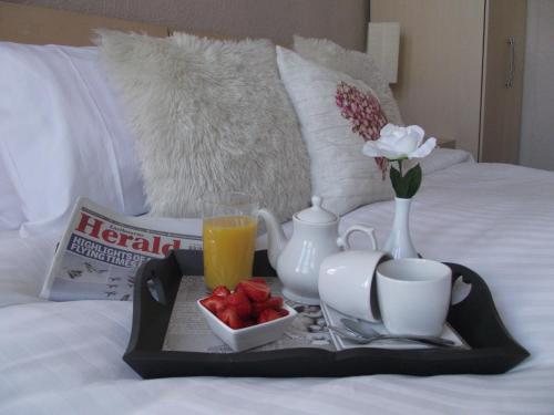 a tray with a tea set on a bed with a breakfast at Ebor Lodge in Eastbourne