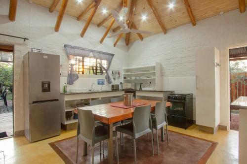 a large kitchen with a wooden table and chairs at Kruger Wild Dog Inn in Marloth Park